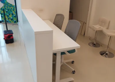 Egyedi gyártású, minimalista fehér irodai pult és munkállomás irodai környezetben