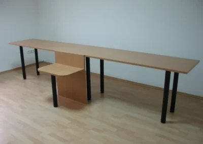 Hosszú, bükk színű irodai asztal fekete fém lábakkal és egyedi központi merevítéssel