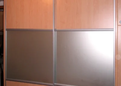 Fa és üveg kombinációjú tolóajtós gardrób modern hálószobában