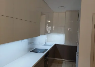 Minimalista fehér konyha modern kialakítással és beépített gépekkel